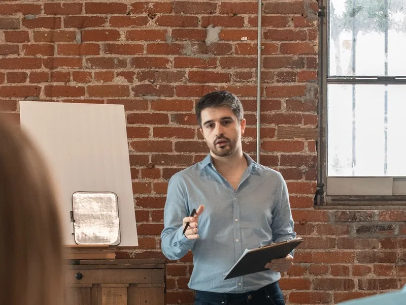 Formateur animant un cours de langue devant des adultes